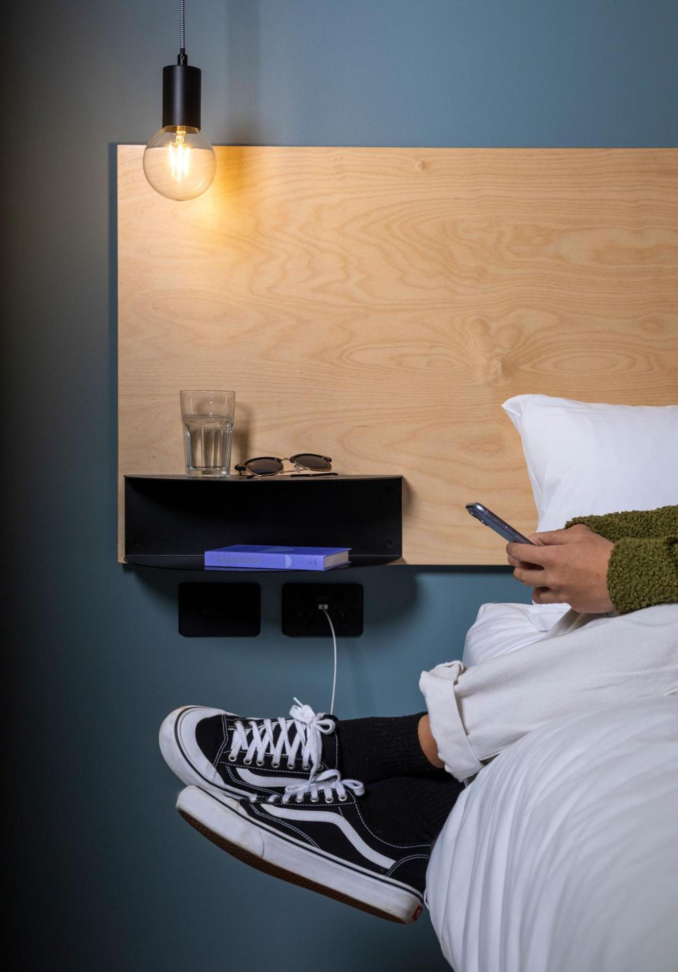 Lylo Auckland Hotel Oda fotoğraf A phone being used in bed